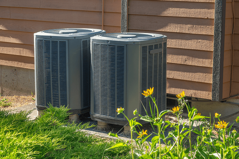 Purchasing the Right Air Conditioner. Photo of an air conditioner unit on the side of a brown building.